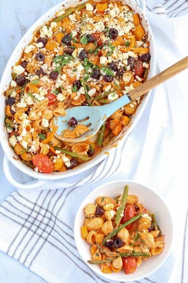 creamy veggie pasta bake in a casserole dish and a small bowl with a serving
