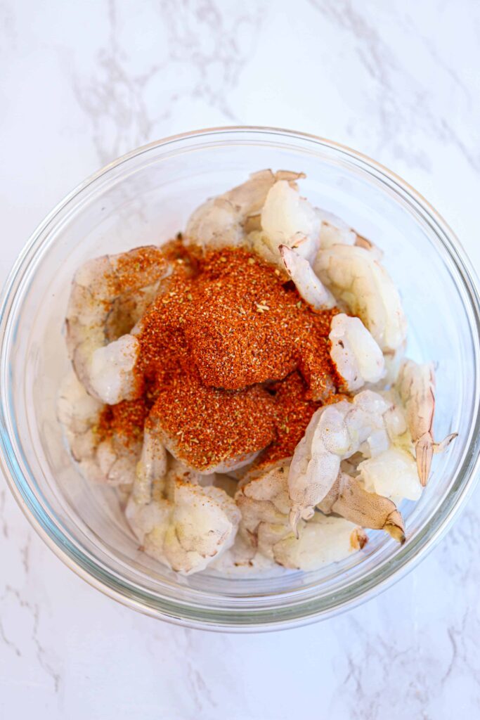 a bowl of raw shrimp with taco seasoning on top