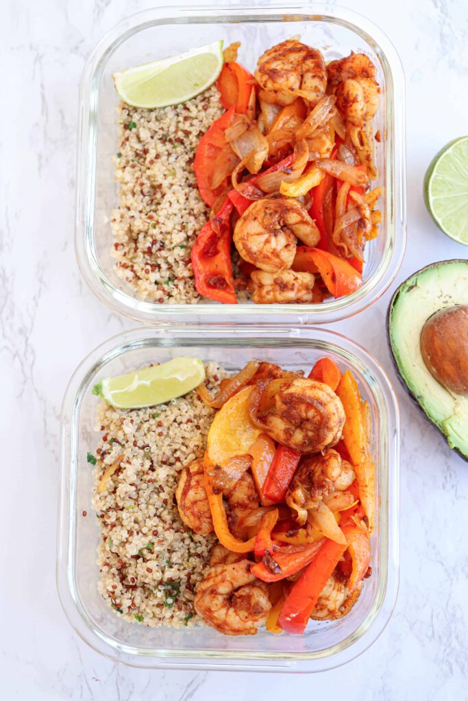 2 glass containers with shrimp fajita bowl meal prep with quinoa and lime