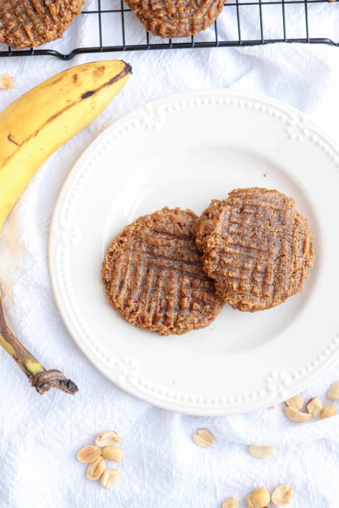 two flourless peanut Butter Cookies on a plate and a banana