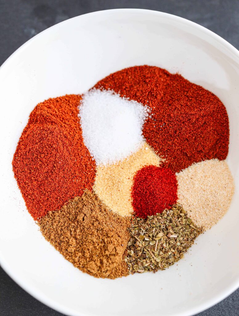 a closeup of taco seasoning 8 spices in a white bowl, unmixed
