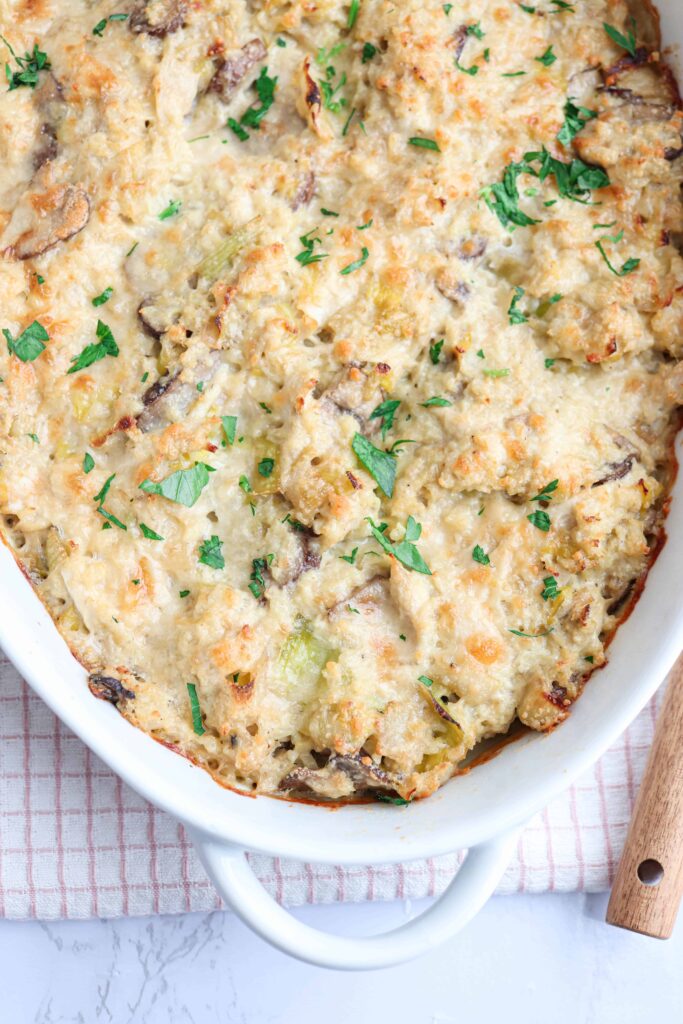 chicken and mushroom cauliflower rice casserole in a white casserole dish on white background close up
