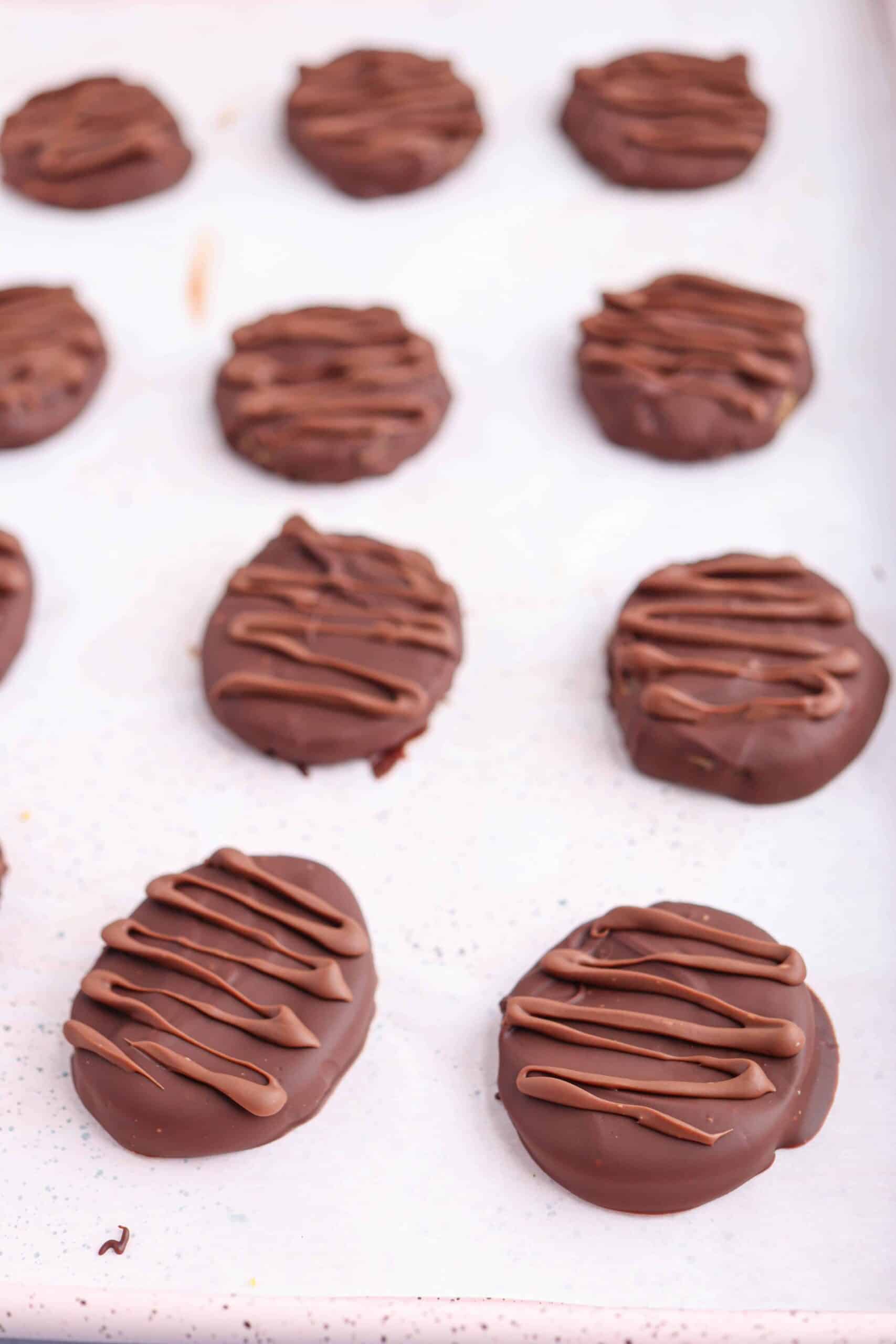 peanut butter eggs in chocolate on light pink surface