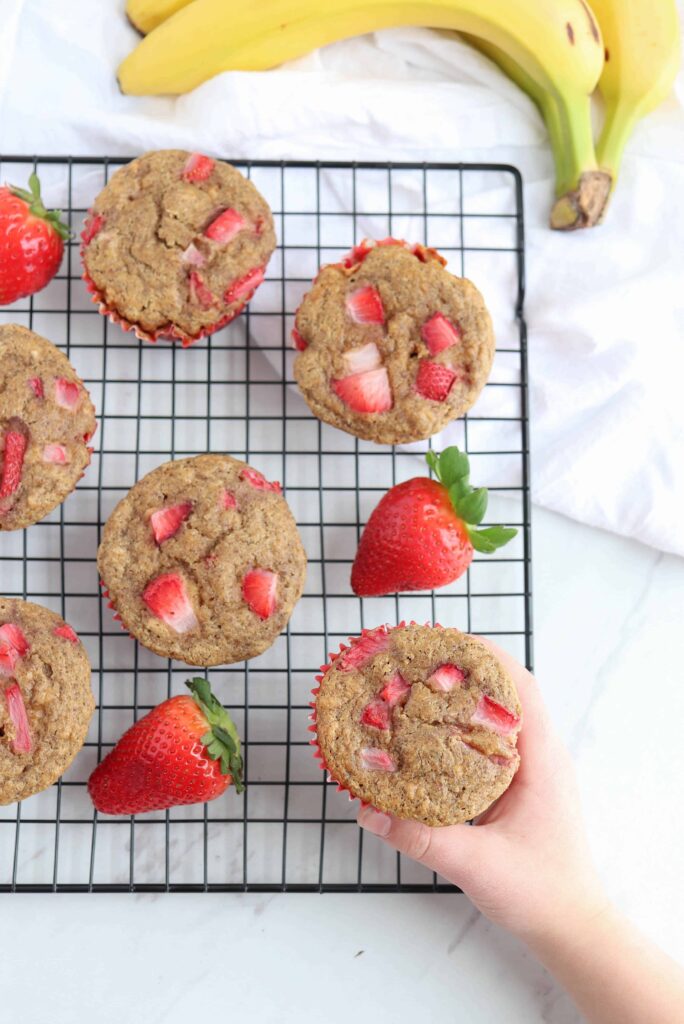 strawberry banana muffins on a black cooling rack.