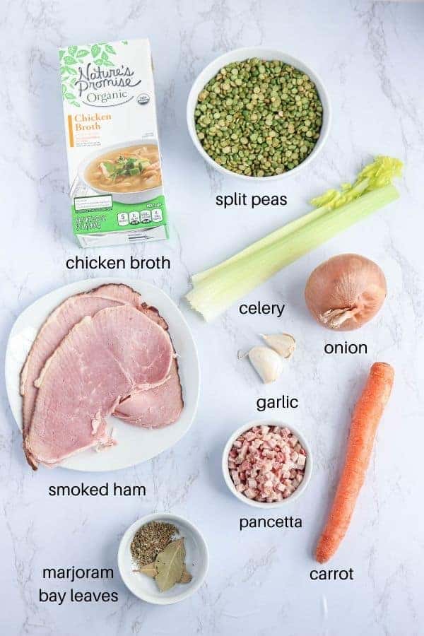 split peas, chicken broth, smoked, pancetta, carrot, ham, garlic, celery, onion and herbs on white marble countertop