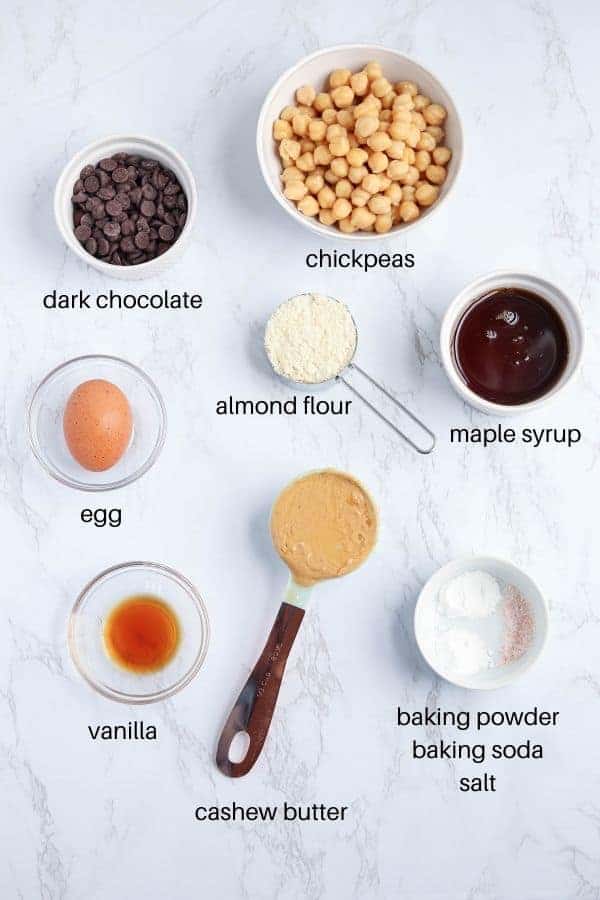 chickpea blondies ingredients laid out on white marble surface with text labels.