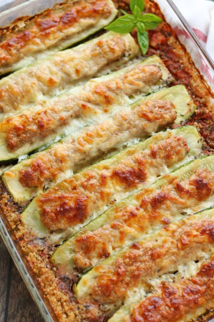 glass pyrex dish with stuffed zucchini boats baked in quinoa and topped with cheese.