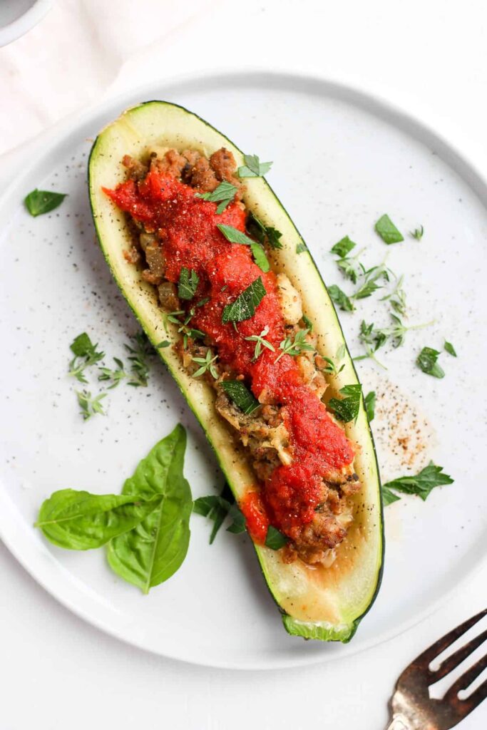 one zucchini boat with mean and tomato sauce.