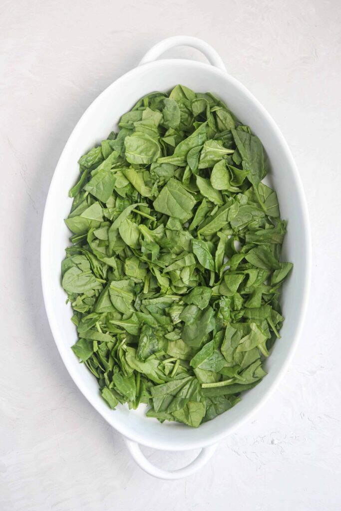 an oval dish with chopped baby spinach