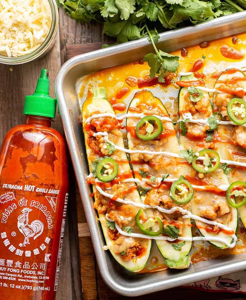 honey sriracha chicken stuffed zucchini boats with jalapeno slices.