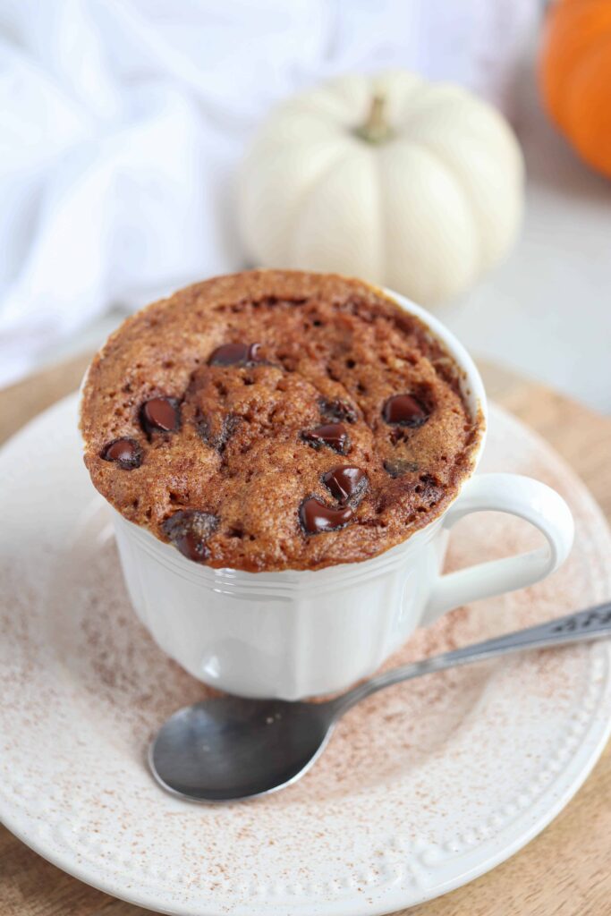 pumpkin mug cake in a white teacup on a saucer