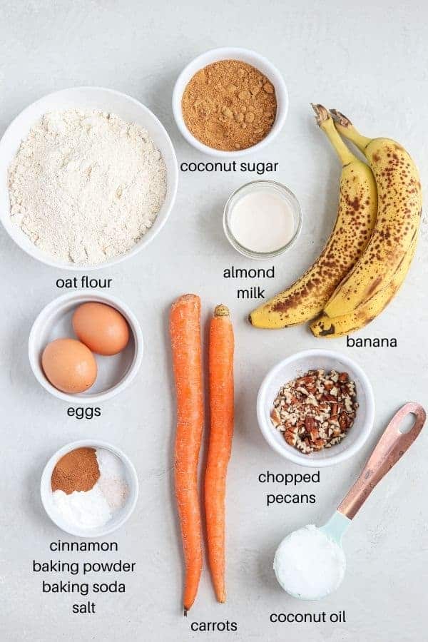 banana carrot oat muffin ingredients laid out on gray surface with labels.