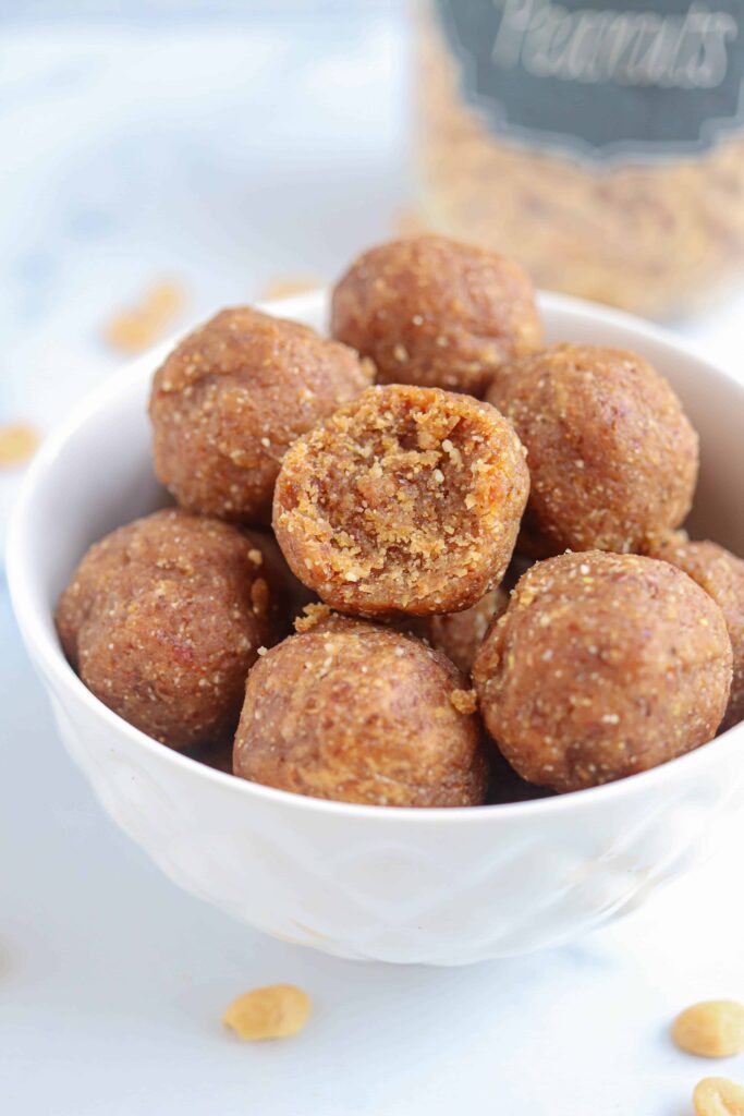 a stack of peanut butter balls in a small white bowl.