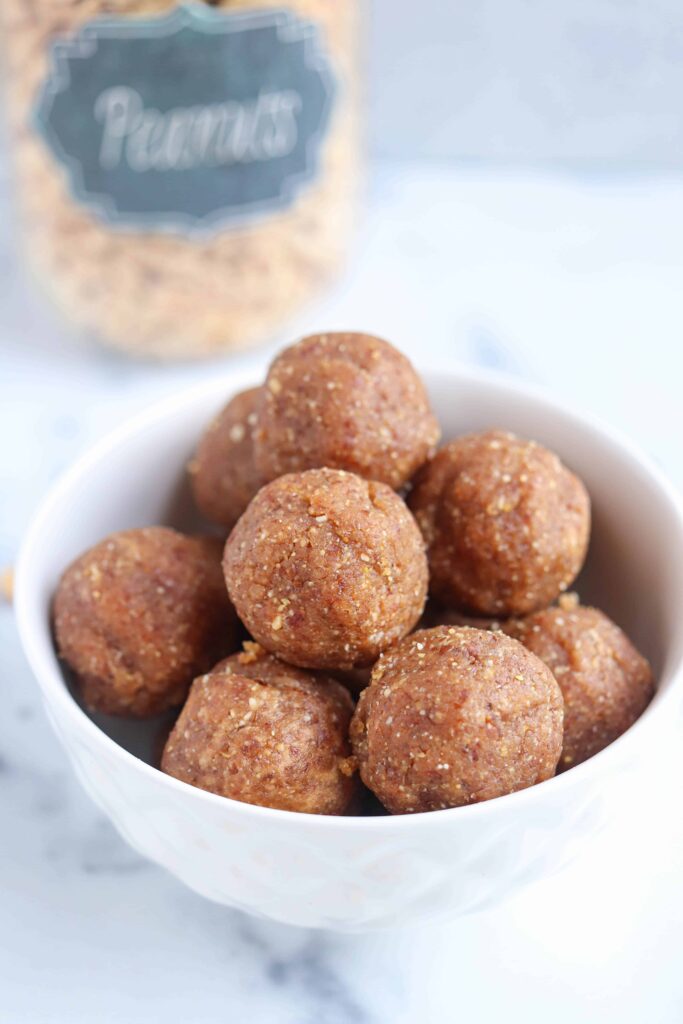 a stack of peanut butter balls in a small white bowl.