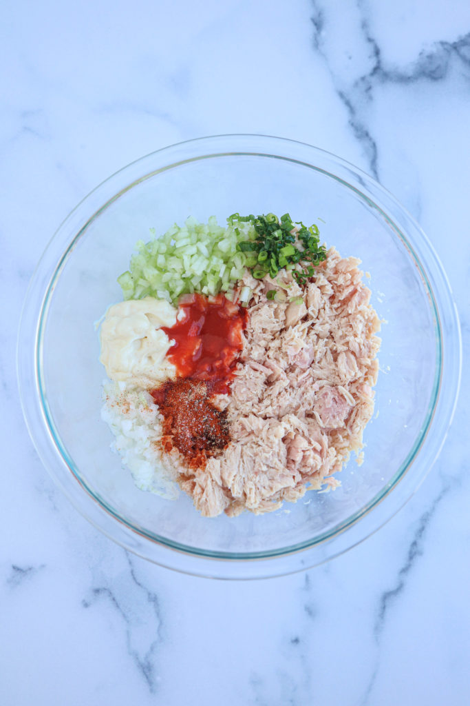 buffalo tuna salad in a glass bowl before mixing ingredients.