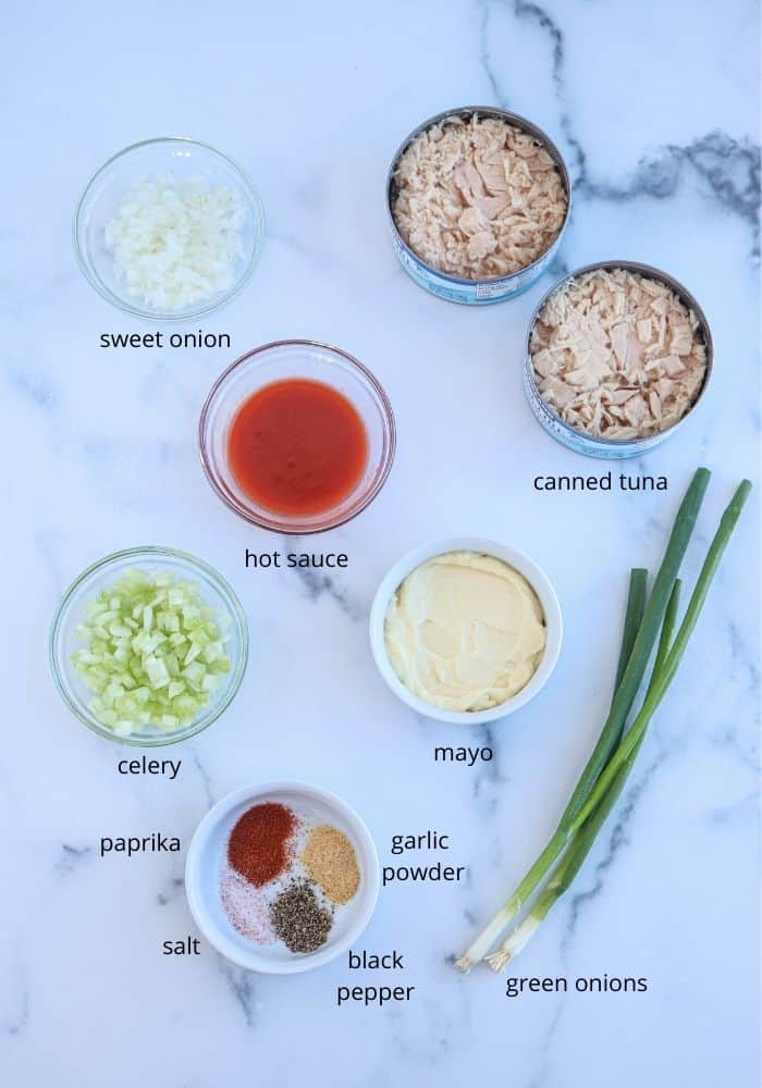buffalo tuna salad ingredients in small round bowls laid out on a white marble surface