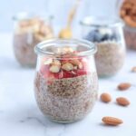 flaxseed pudding topped with fresh strawberries and chopped almonds on white marble surface