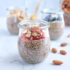 flaxseed pudding topped with fresh strawberries and chopped almonds on white marble surface