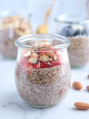 flaxseed pudding topped with fresh strawberries and chopped almonds on white marble surface