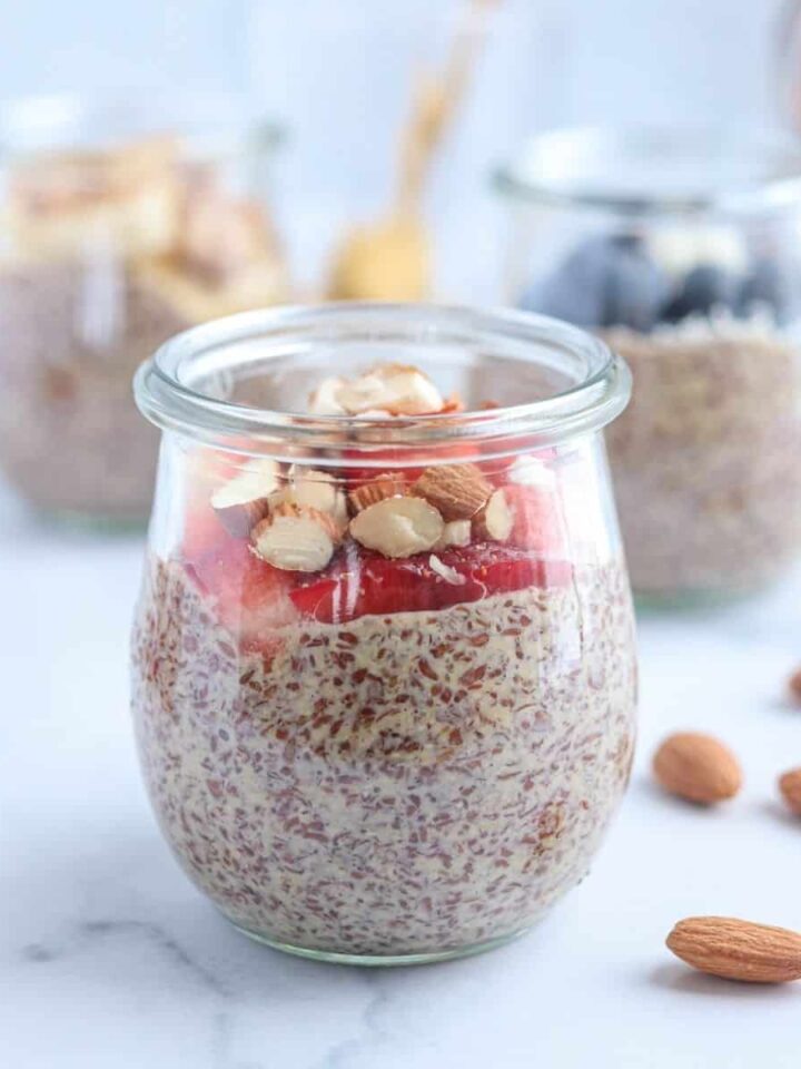 flaxseed pudding topped with fresh strawberries and chopped almonds on white marble surface
