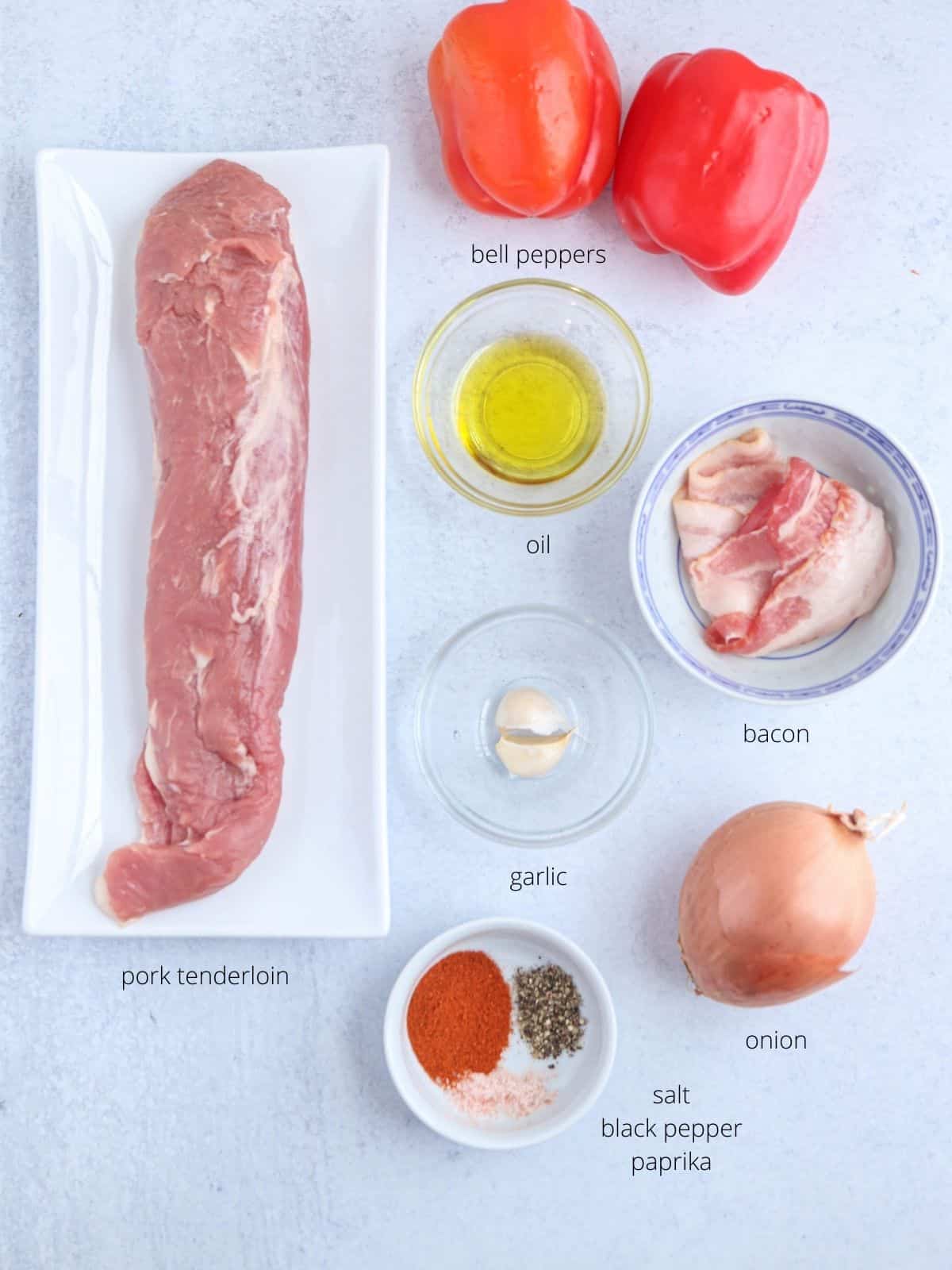 pork kebabs ingredients laid out on light gray surface in containers with labels.