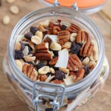 an open jar of low-carb trail mix on a wooden surface.