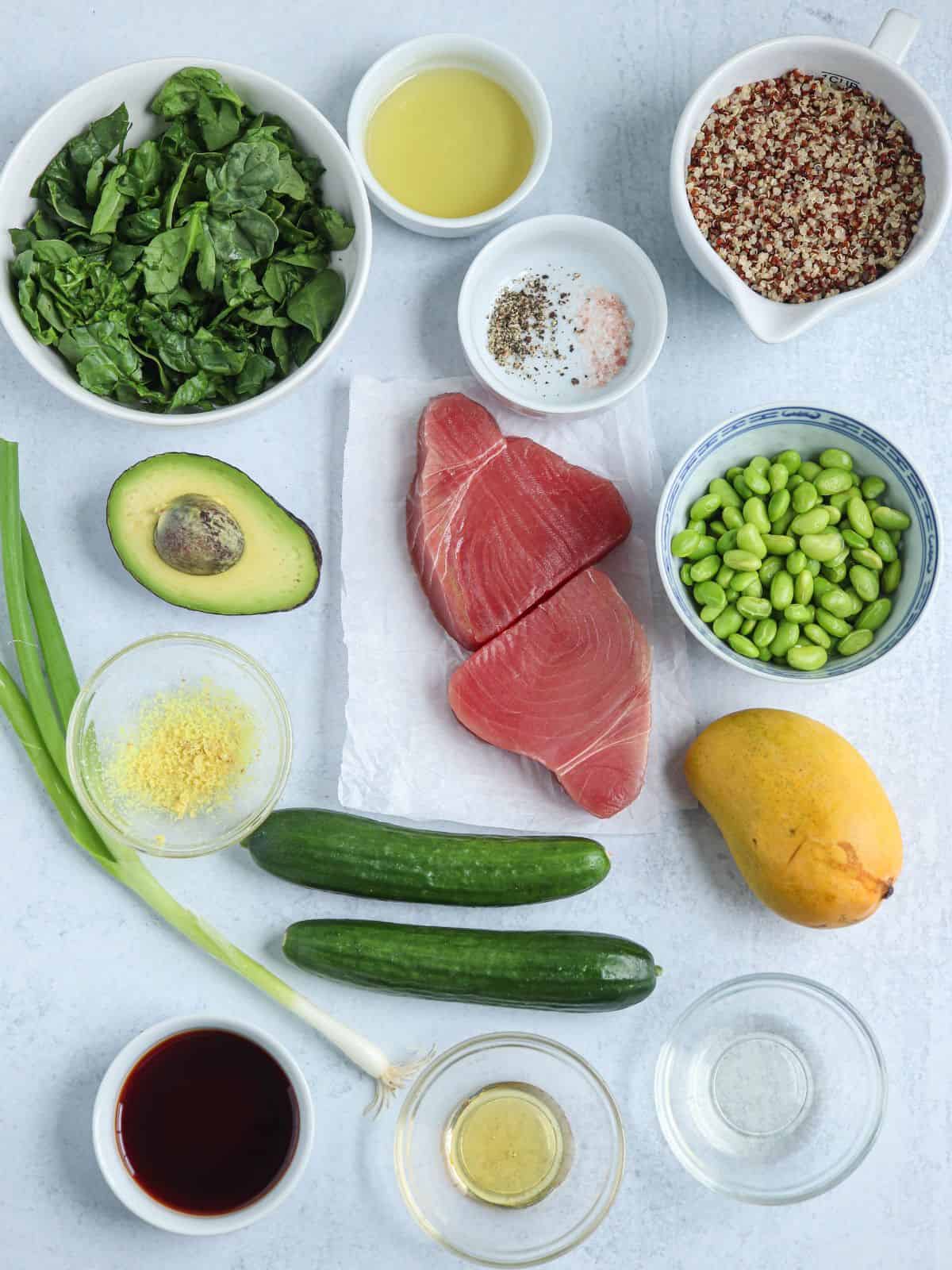 ingredients to make quinoa poke bowls with ahi tuna on light gray surface in small containers.