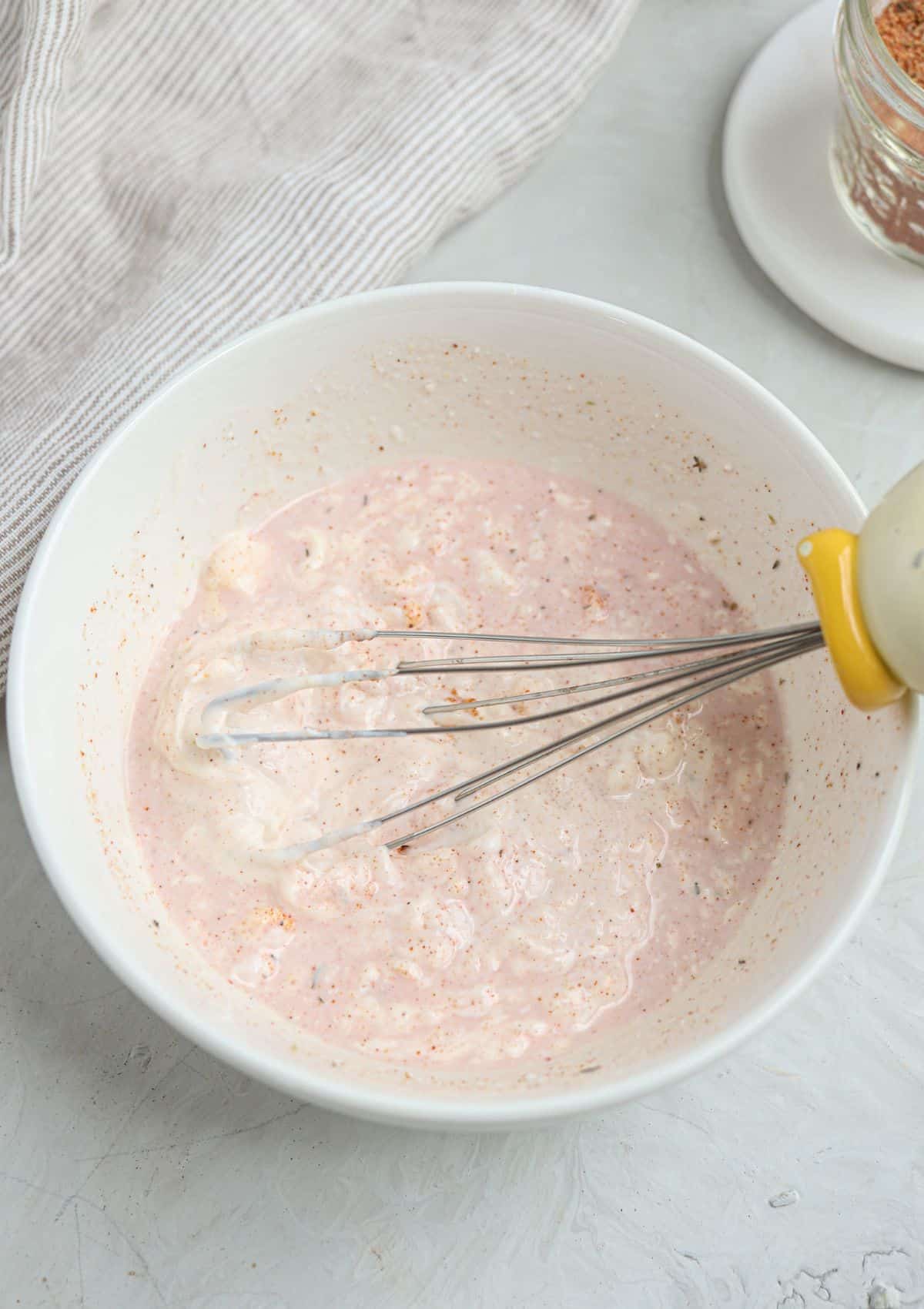 mixing creamy cajun salad dressing.