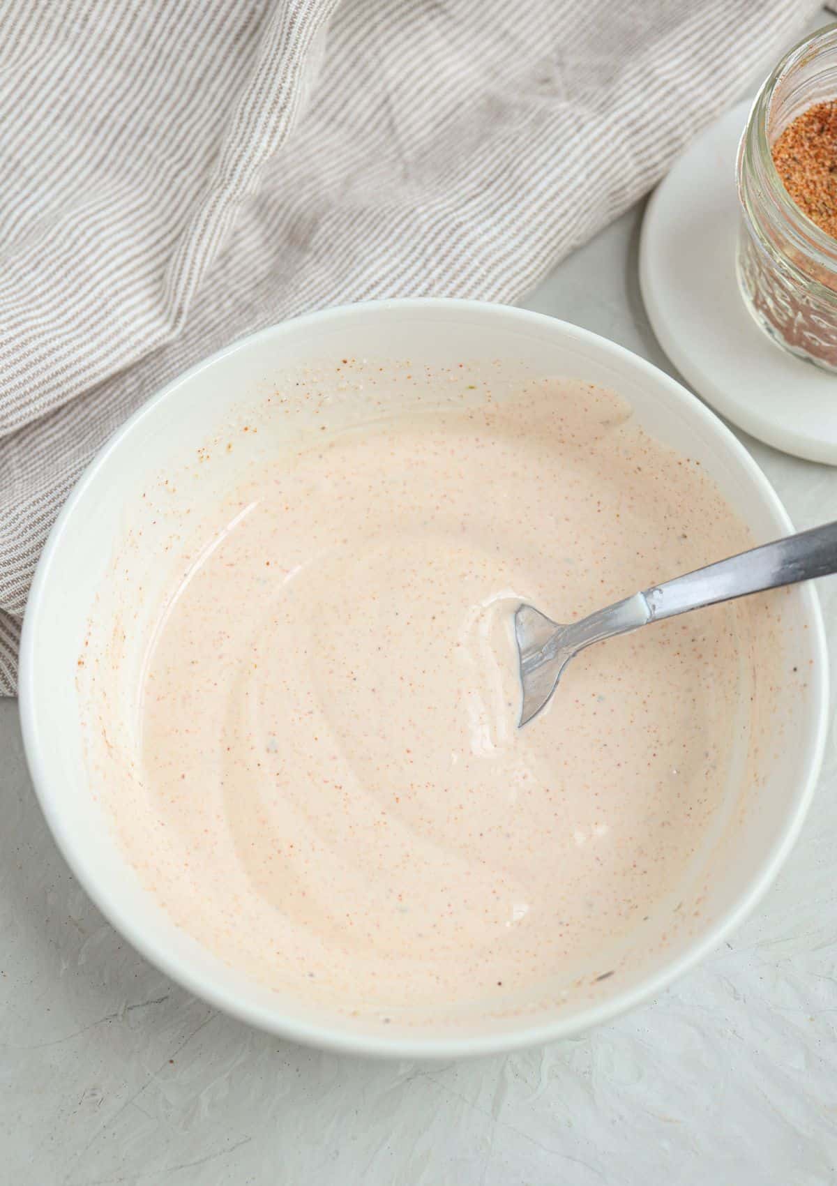 creamy cajun salad dressing in a small white bowl.