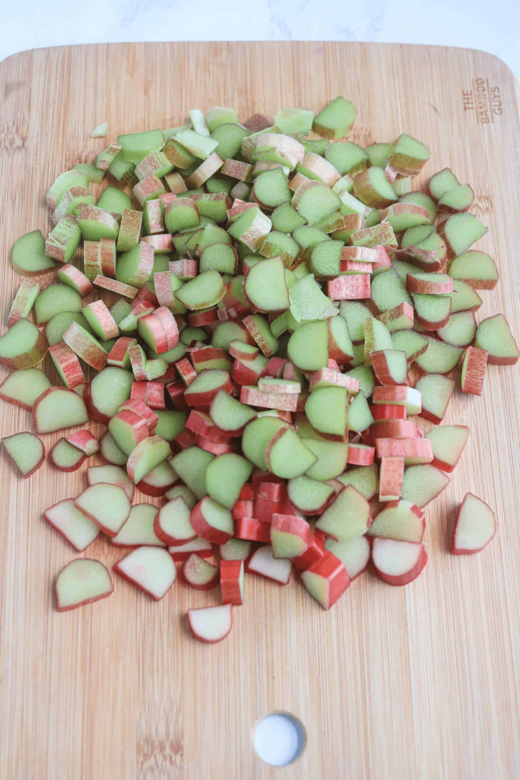 rhubarb cut up on a bamboo cutting board.