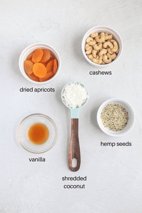healthy apricot balls ingredients on light gray surface with captions. 