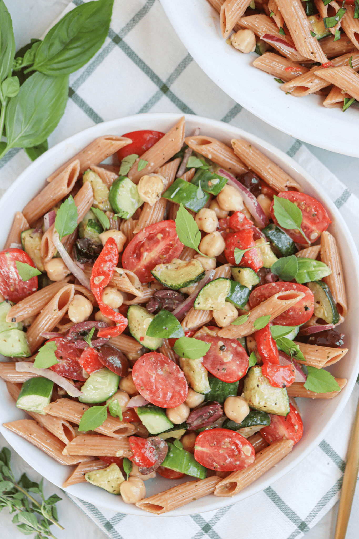 red lentil pasta salad with vegetables and dressing in a white bowl.
