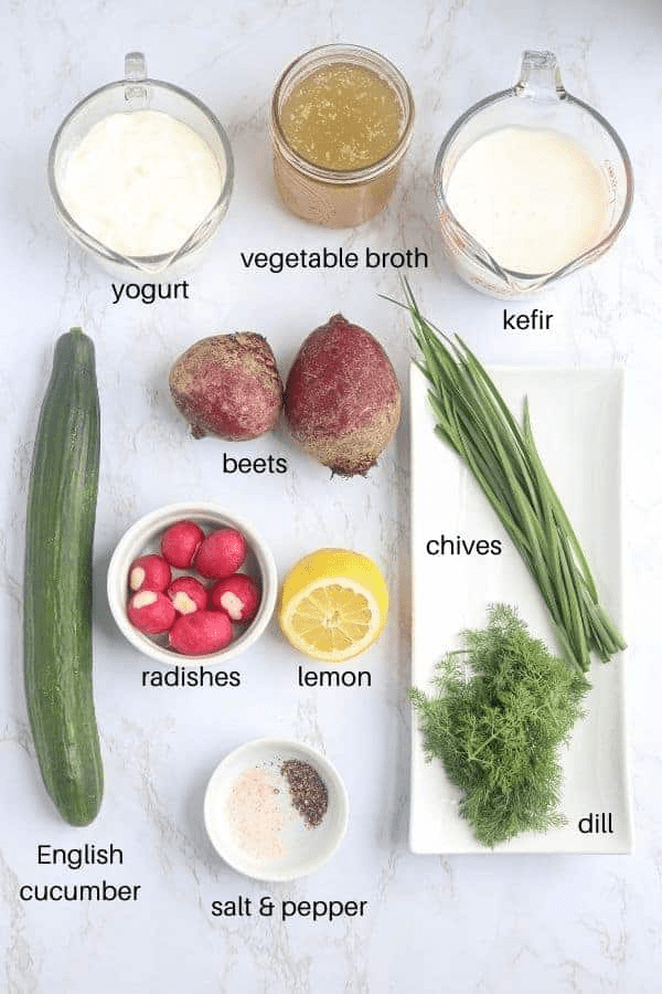 ingredients for making Polish cold beet soup on white marble surface with captions.