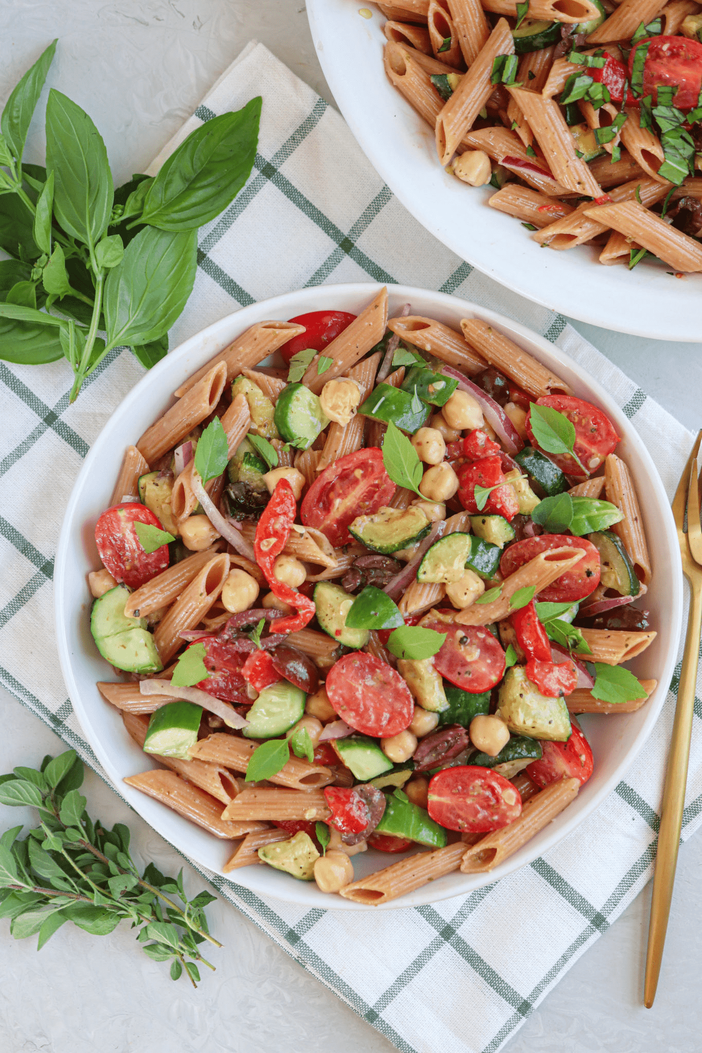 red lentil pasta salad with vegetables and dressing in a white bowl.