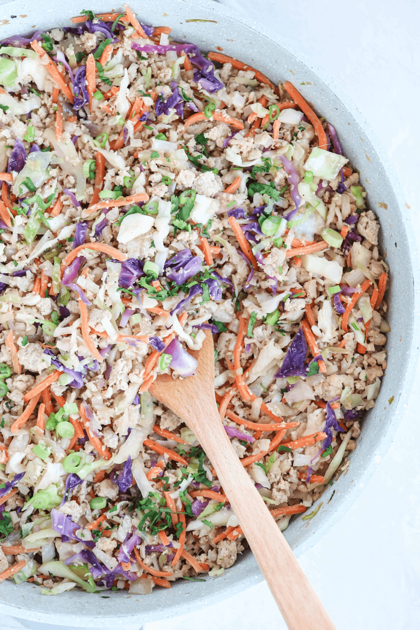 egg roll in a bowl dish in a large teal skillet. 