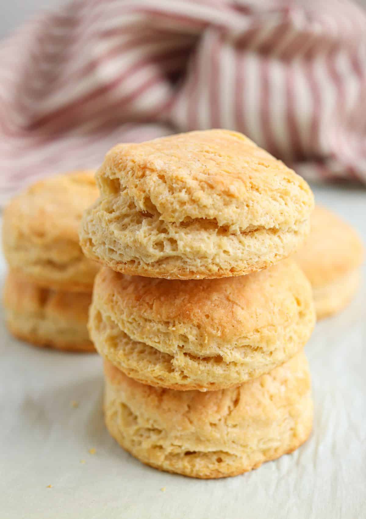 a stack of three golden brown biscuits on parchment paper.
