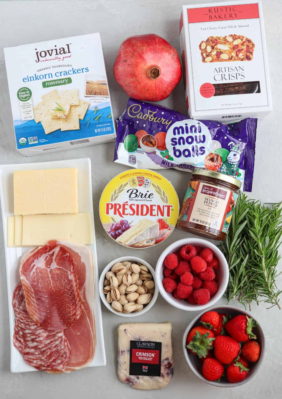ingredients to make a Christmas charcuterie board on light gray surface.