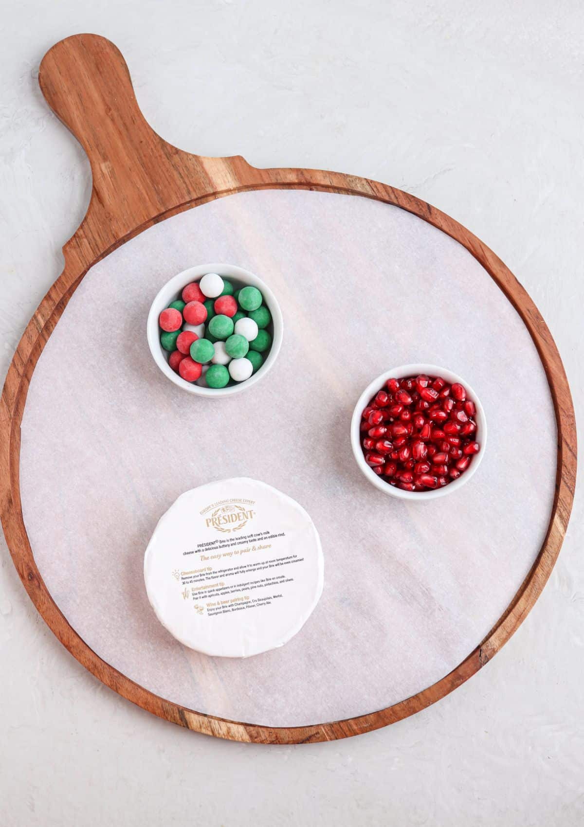 steps for making a Christmas charcuterie board on a round wooden board.