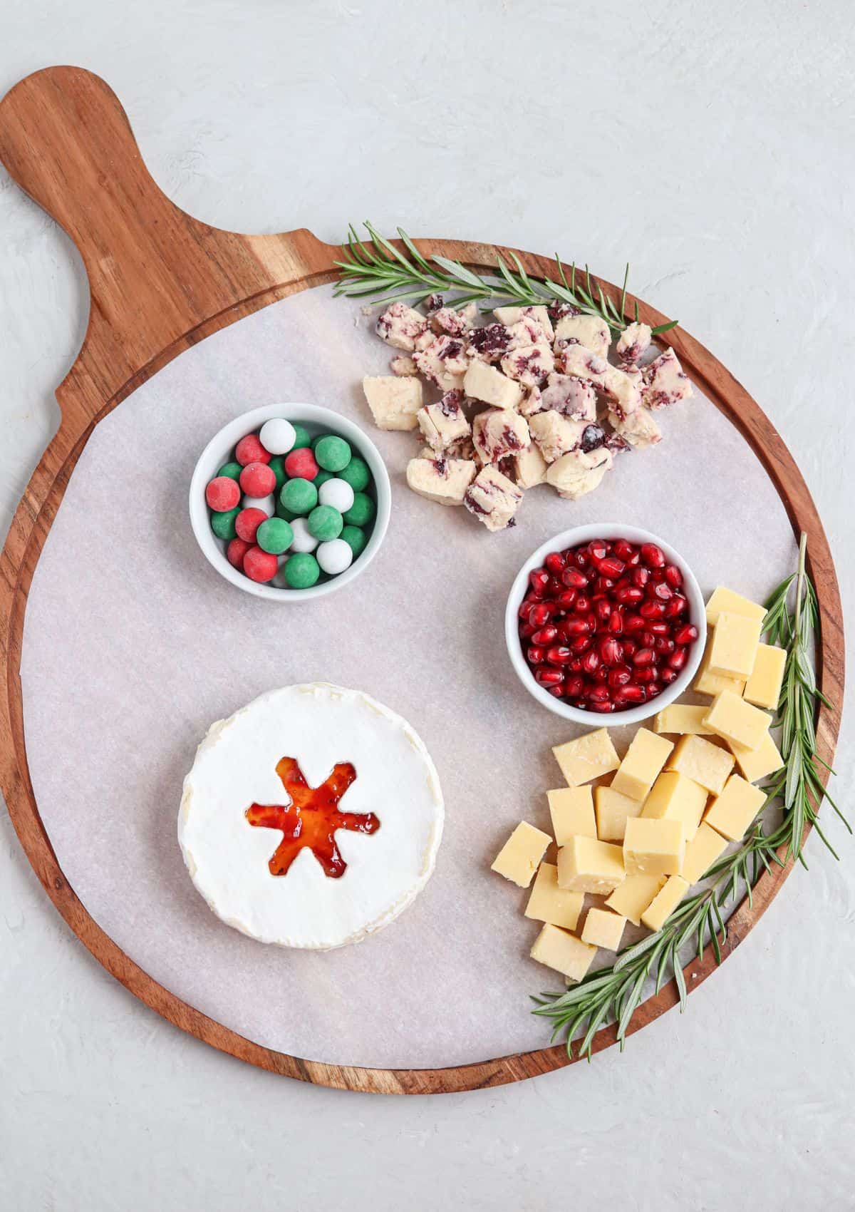 steps for making a Christmas charcuterie board on a round wooden board.