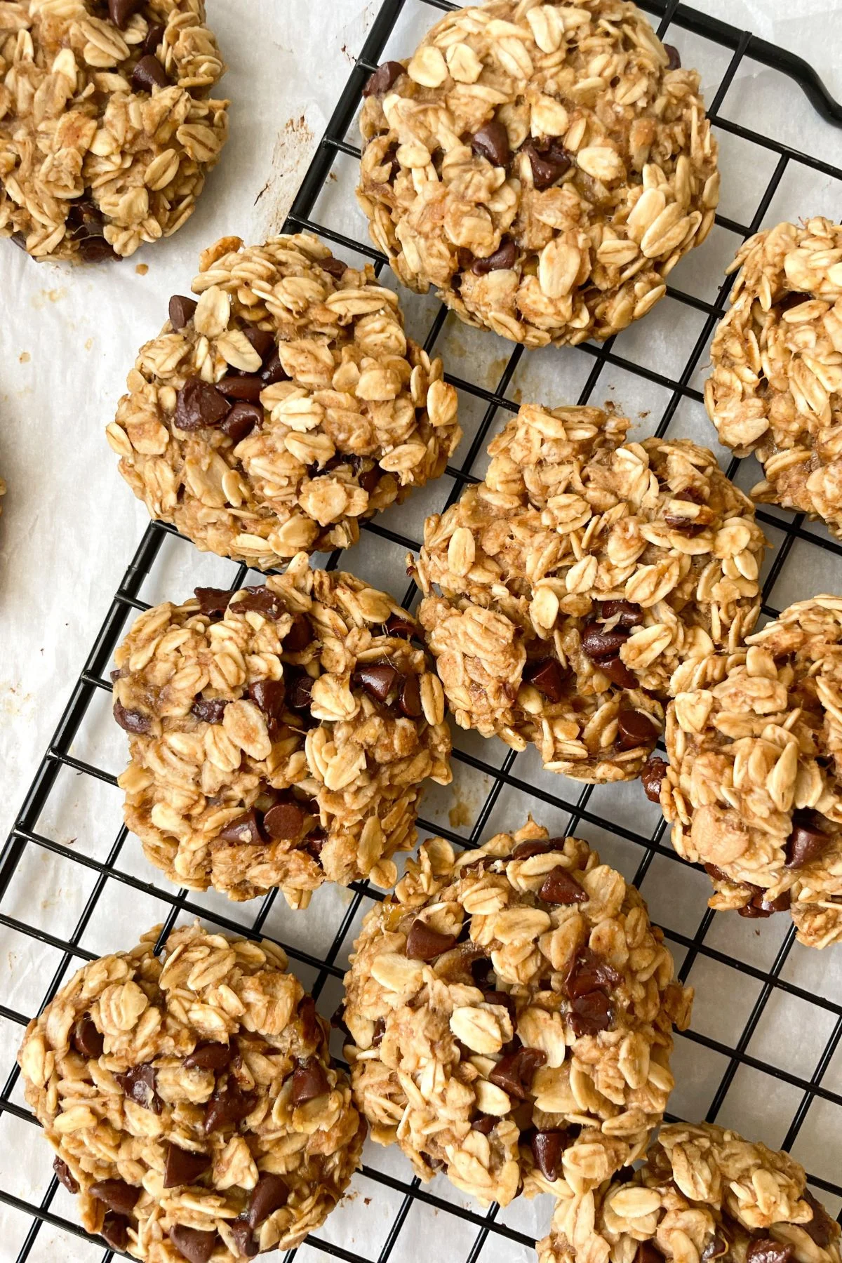 banana oatmeal cookies with chocolate chips on a black cooling rack.