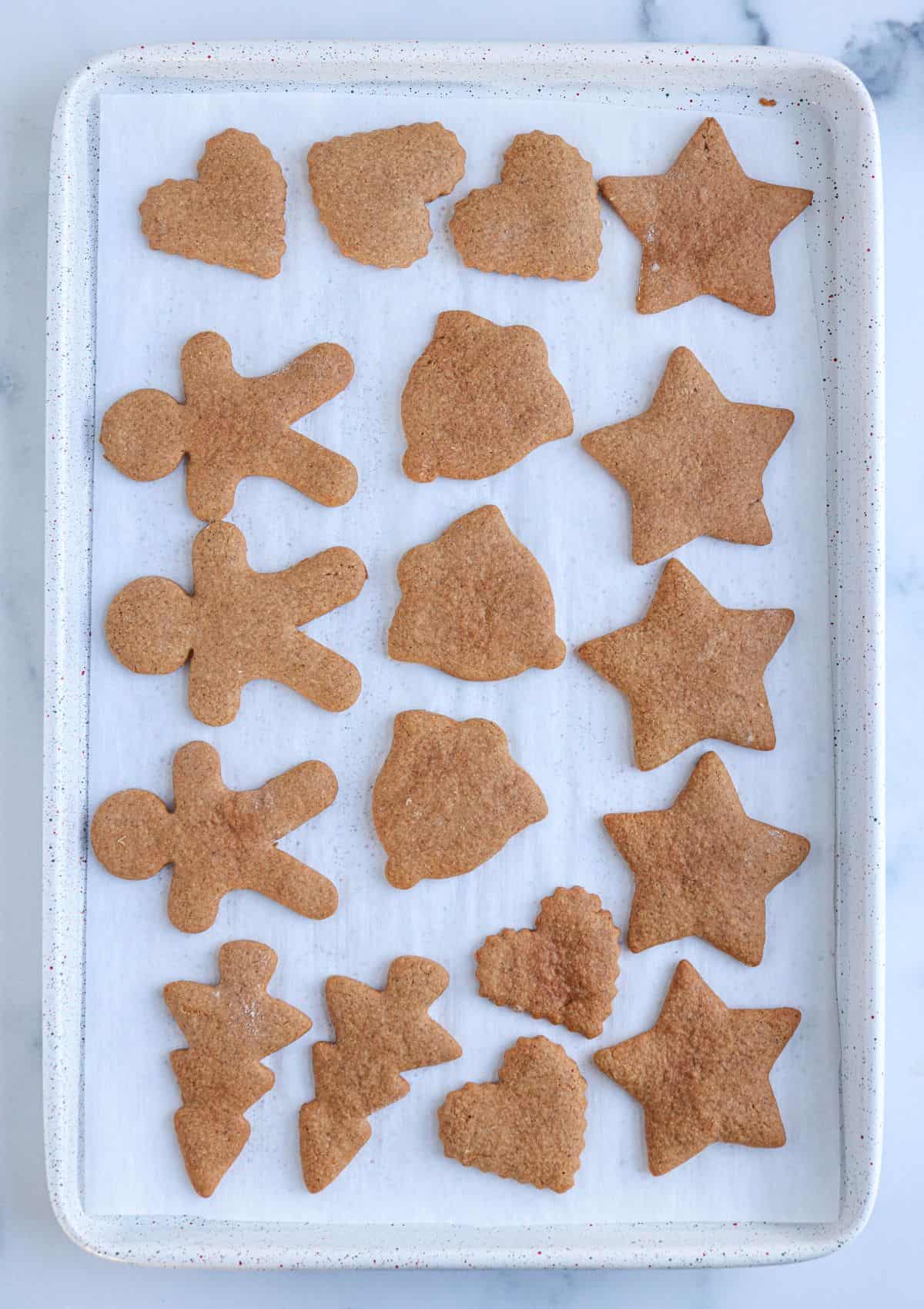 Polish gingrebread cookies on a white cookie sheet on parchment paper, after baking. 