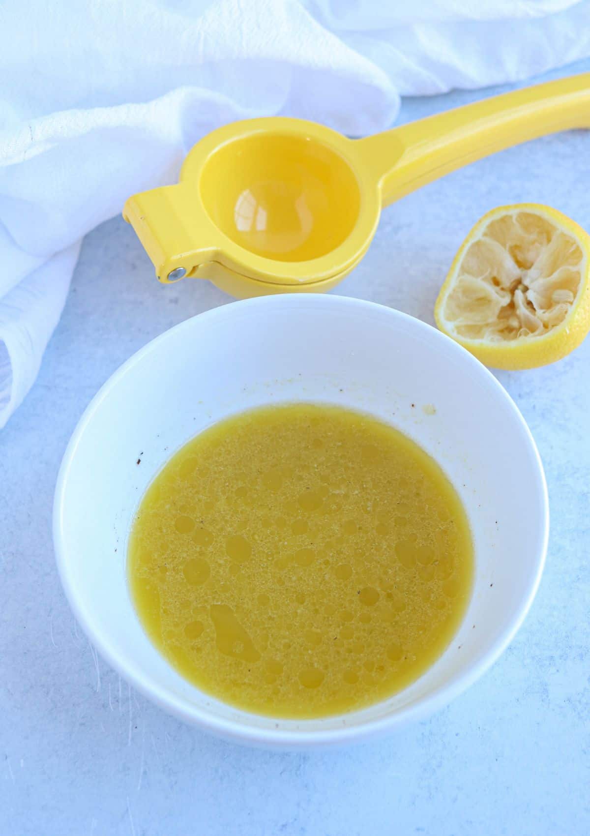 lemon salad dressing in a small white bowl.