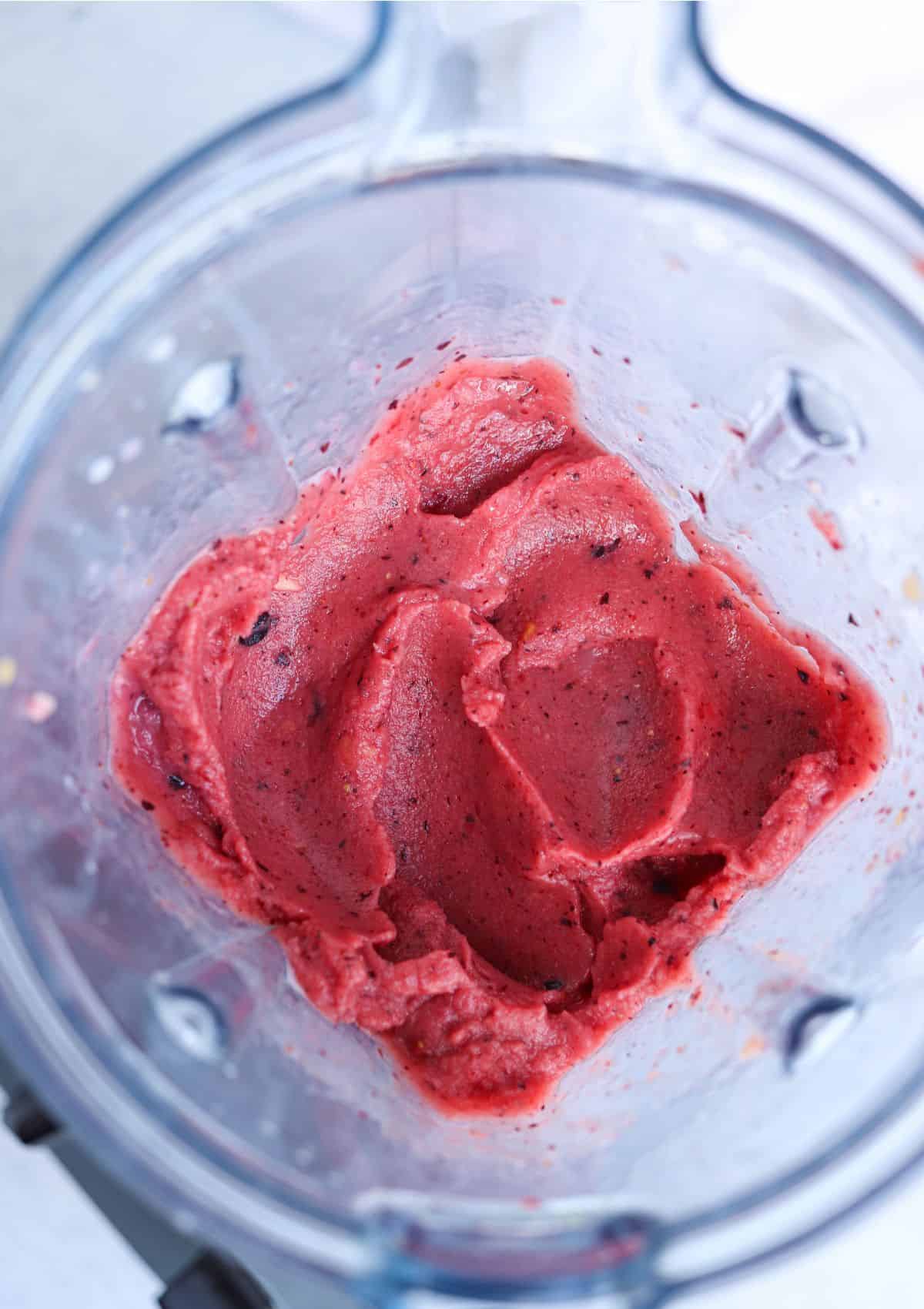 thick mango berry smoothie bowl after blending in the jug of a blender.
