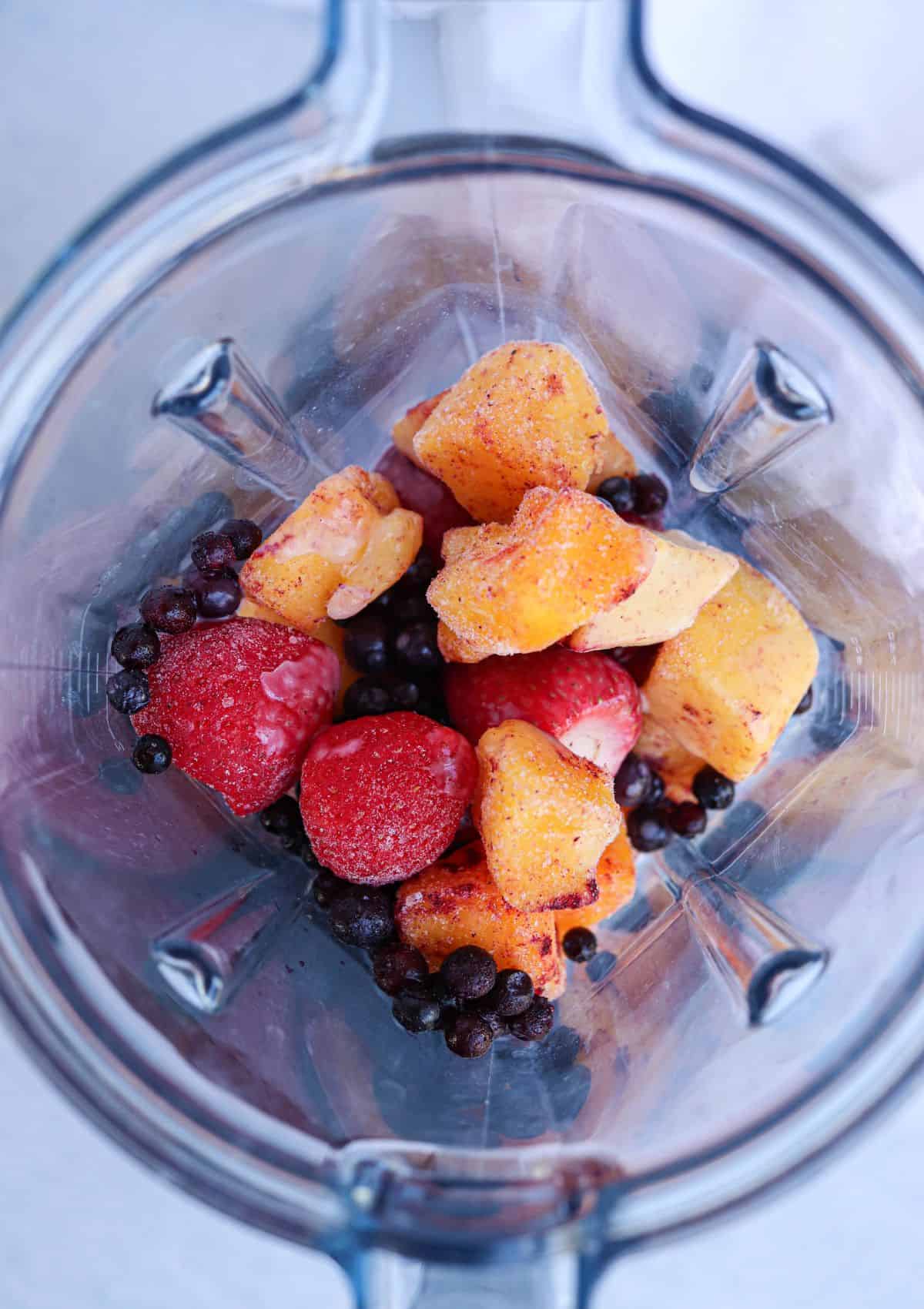 mango berry smoothie bowl in a blender before blending.