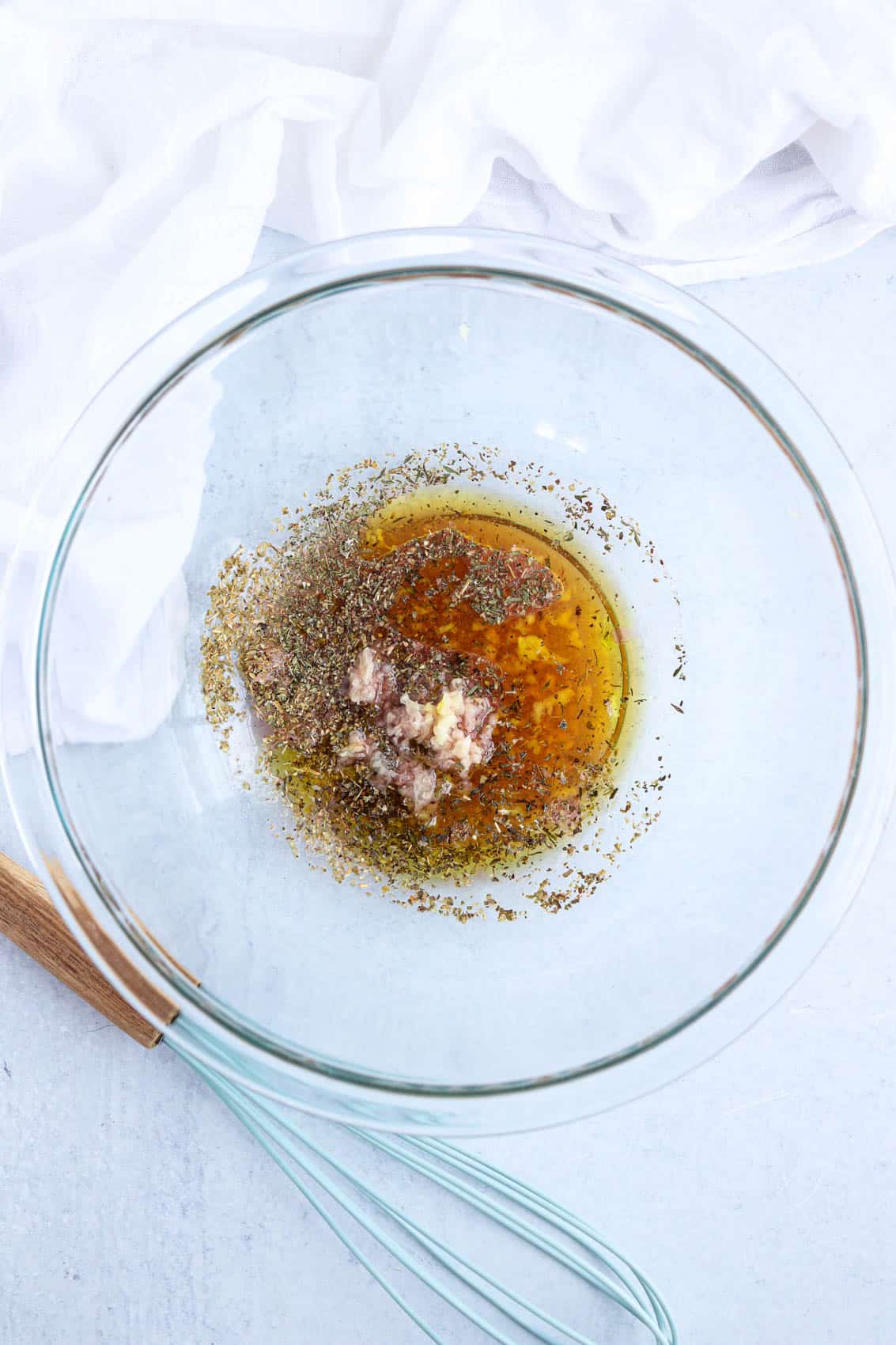 marinade made with oil, garlic and spices in a glass bowl.