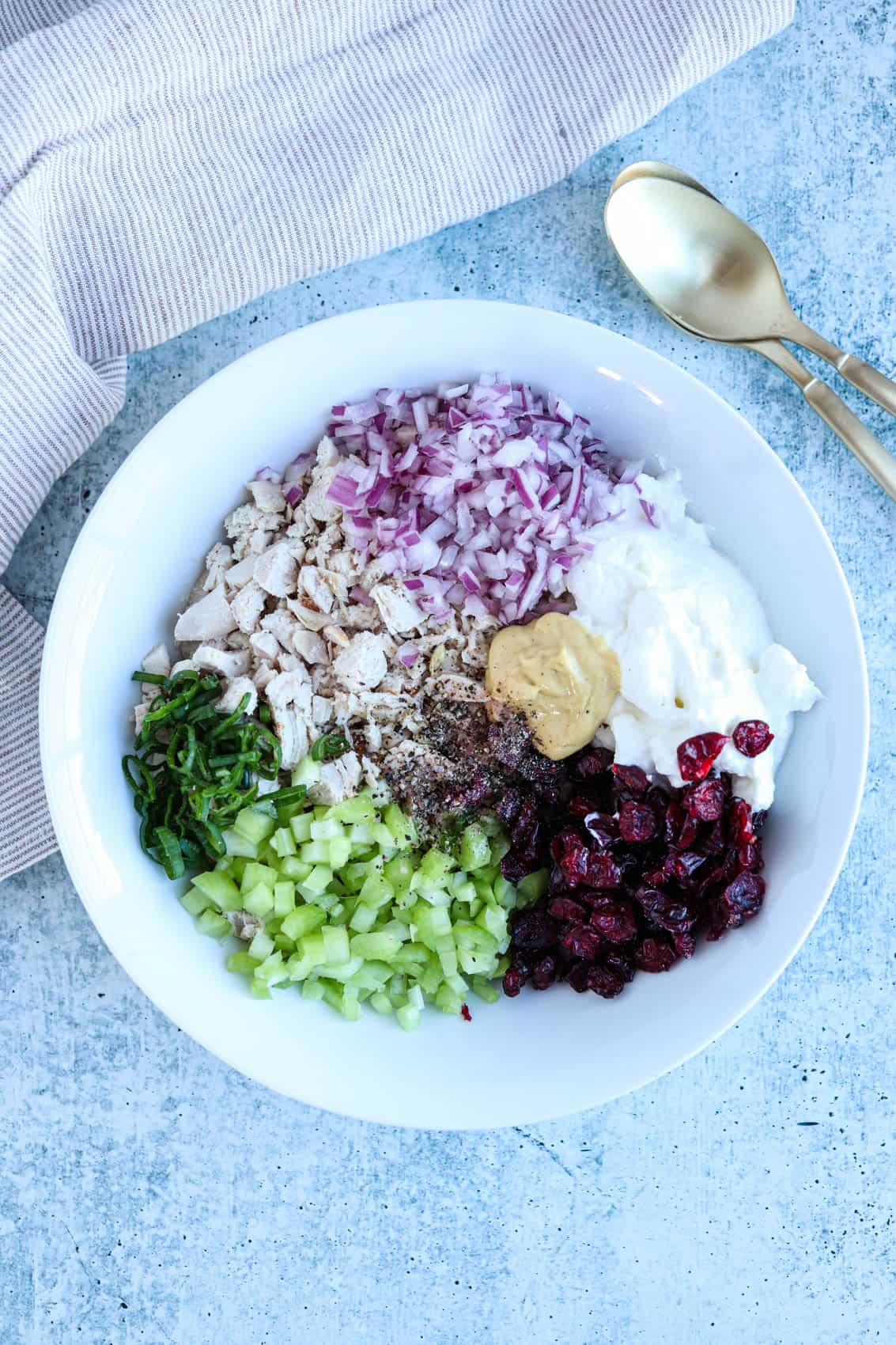 no mayo chicken salad with cranberries, celery and red onion before mixing in a white bowl. 