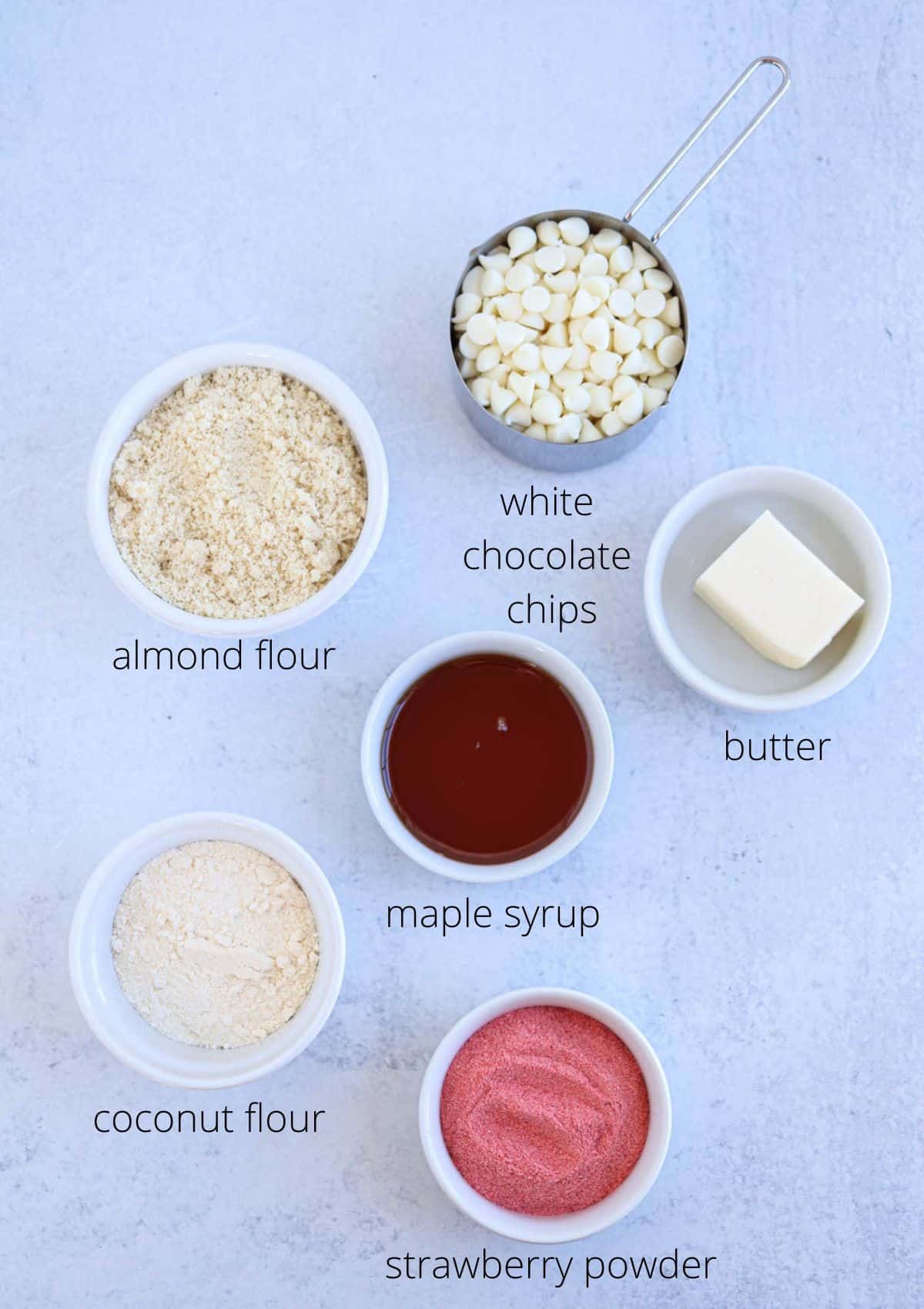 ingredients for making strawberry cake pops in small round containers with captions.