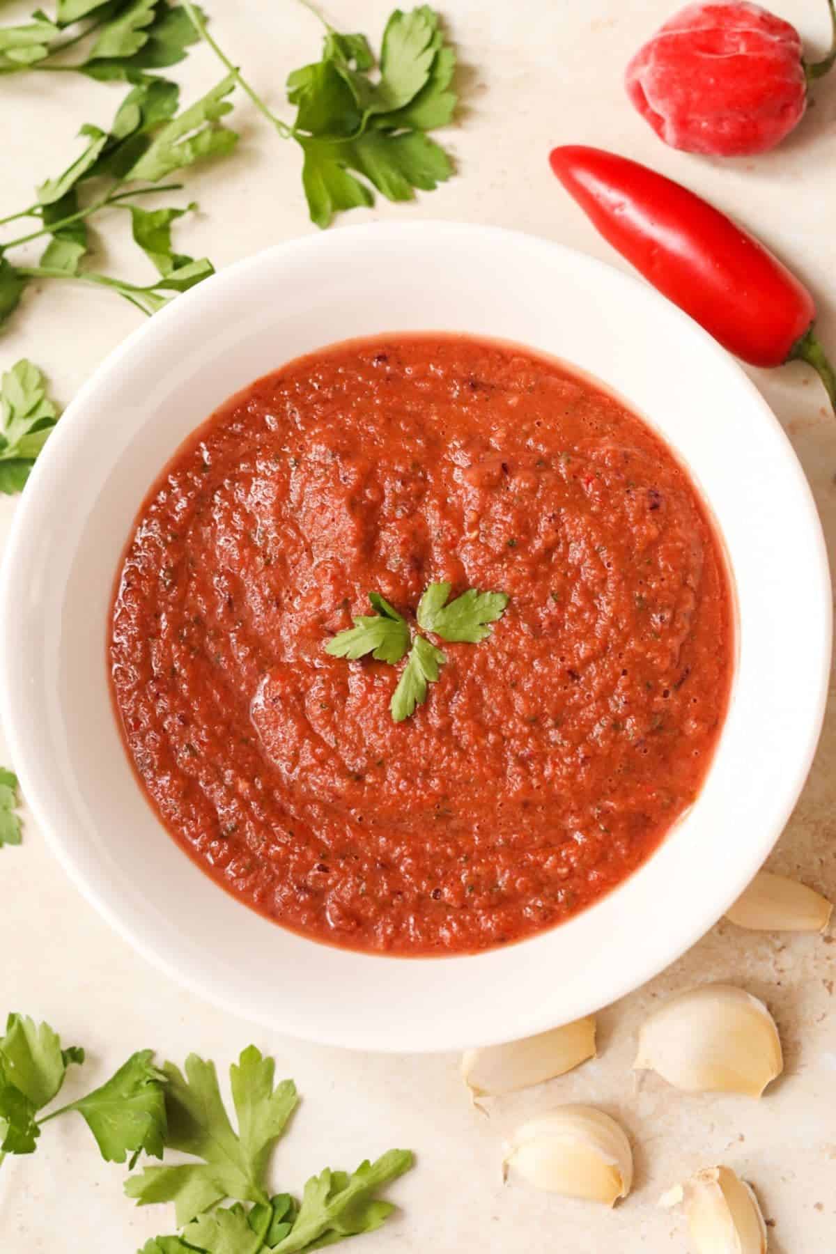 bright red chilli sauce in a white bowl.
