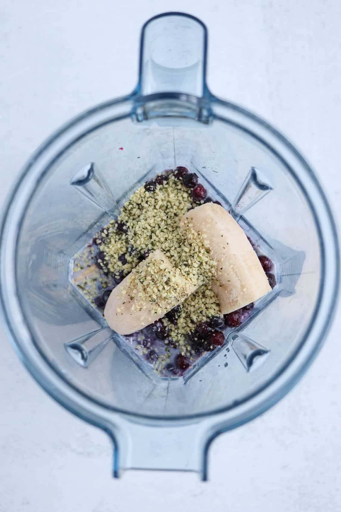 banana, blueberries and hemp hearts in a jug of a standup blender.