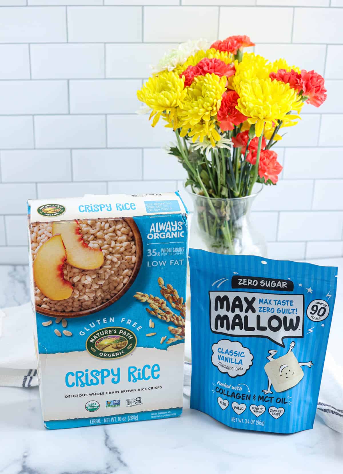 brown rice crispy cereal and a bag of healththy marshmallows on a white marble kitchen counter.